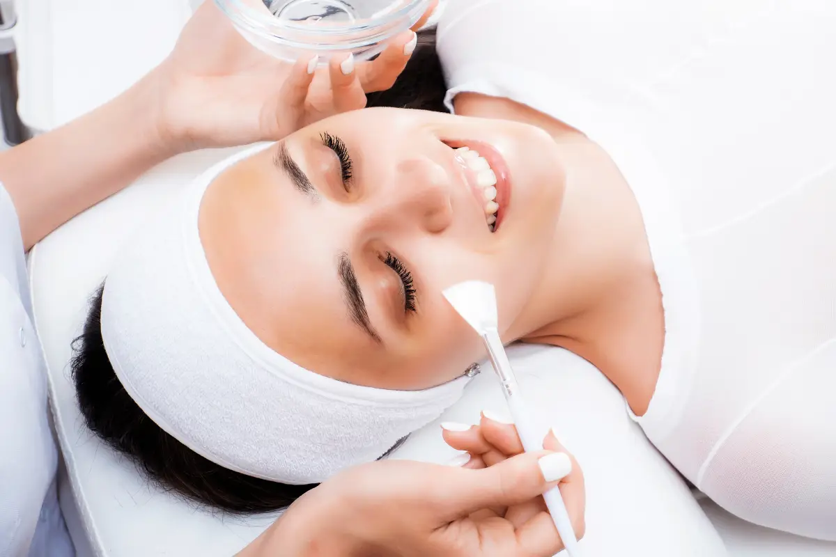 a woman lying down with a brush and a bowl of water