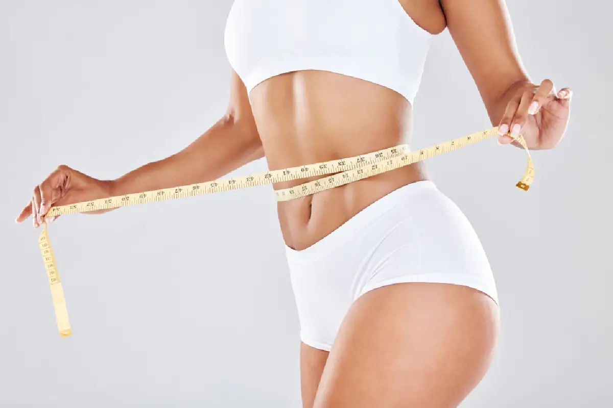 a woman measuring her waist