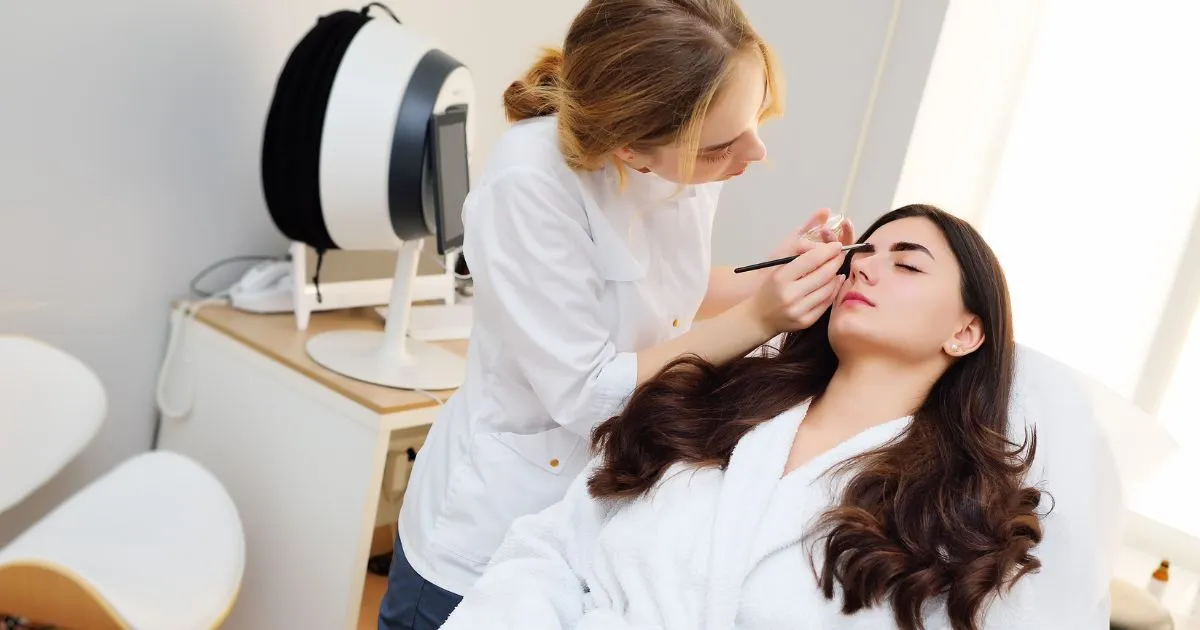 Esthetician applies semi-permanent makeup to a client's eyebrows in Savannah, GA